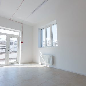 Office extension that uses bricks as a wall, construction, improvement. Interior of small room with window and bricks walls renovation, extension, overhaul and reconstruction.