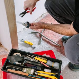 Top view of unrecognizable plumber doing heating installation on a construction site